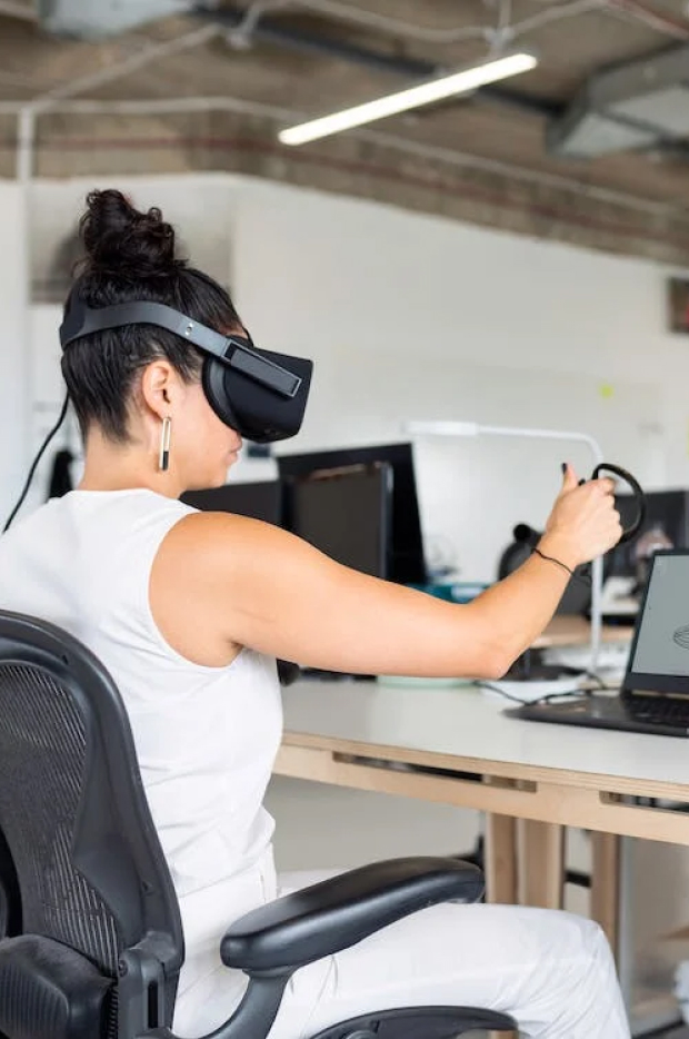 Osoba koja nosi headset virtuelne stvarnosti i drži kontroler, angažovana u impresivnom iskustvu, možda u virtuelnom sastanku ili simulaciji.